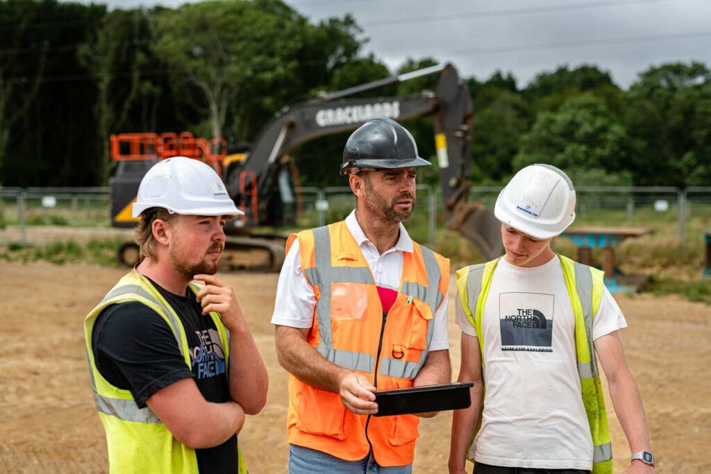 An instructor and two apprenticeships discussing solutions to a problem. Bespoke Courses.
