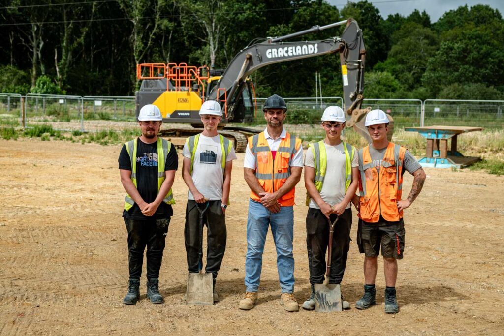 A team of apprentices standing inline with their instructor, how we support you.